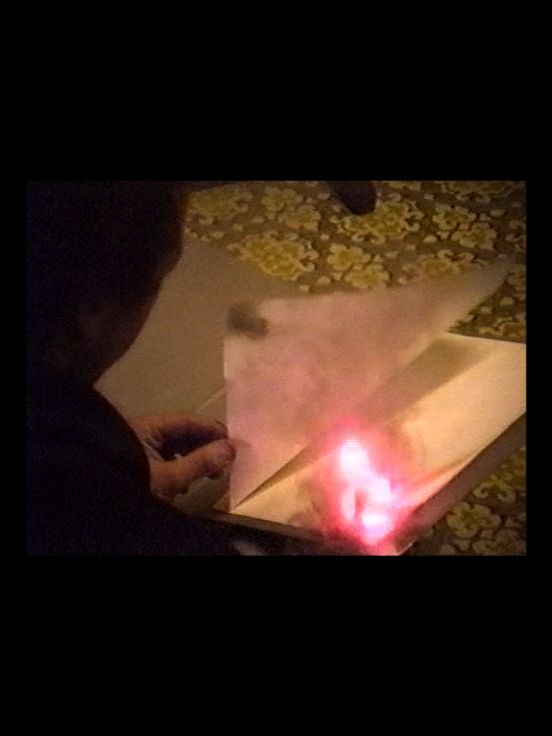 Archival material: Side view of an unrecognisable person turning a page of a burning book.