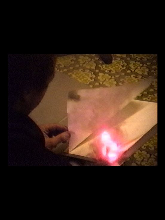 Archival material: Side view of an unrecognisable person turning a page of a burning book.