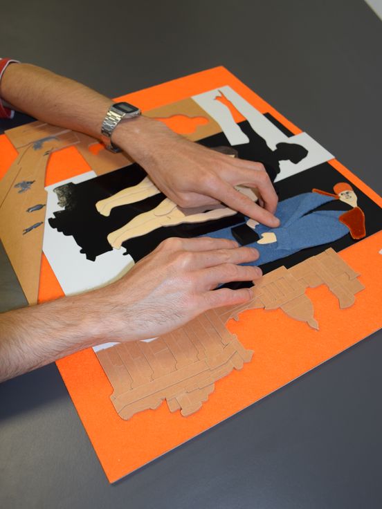 Foto: Zwei Hände betasten ein Tastmodell mit unterschiedlichen Materielien.