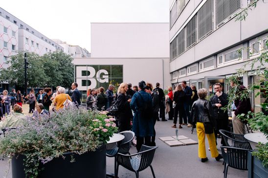 Foto: Menschen in kleineren und größeren Grüppchen vor dem Café Dix auf dem Vorplatz der Berlinischen Galerie.