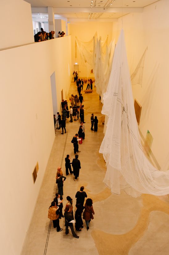 Foto: Eindrücke des Eröffnungsabends, die Menschen entweder bei der Verleihung in der Treppenhalle der Berlinischen Galerie oder zwischen Jeewi Lees Installation im Ausstellungsraum zeigen.