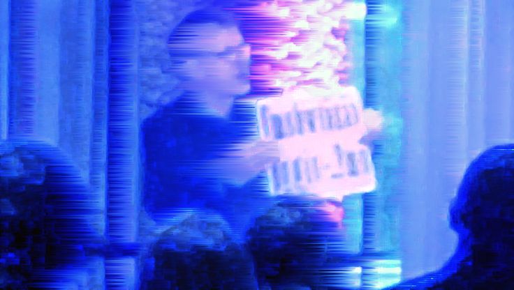 Foto: Leicht verschwommenes Porträtfoto von Florian Kaplick bei einer Performance. Das Foto ist in leuchtenden Farben gehalten.