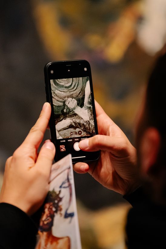 Photo: Scenes from the opening night, showing people either listening to the opening speeches in the staircase hall of the Berlinische Galerie or in the exhibition rooms.